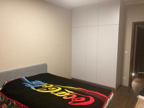 Una habitación con una cama con una manta de béisbol. en Smile Apartment, en Osielsko