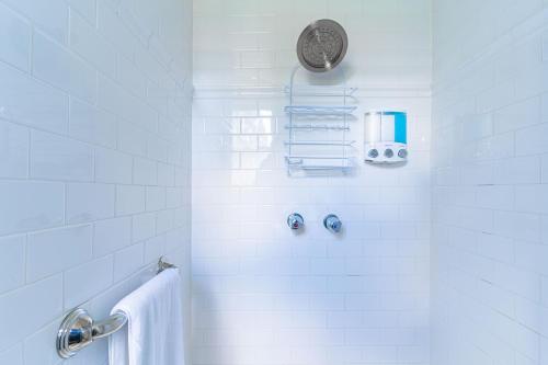 a white bathroom with a shower with a towel at The Estate at Mt Dora in Mount Dora