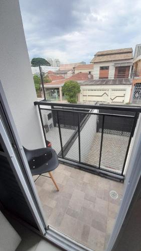 a black chair sitting on a balcony with a view at Casa Nova Tatuapé in Sao Paulo