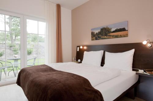 a bedroom with a large bed with a large window at Hotel Meiners in Kirchhatten