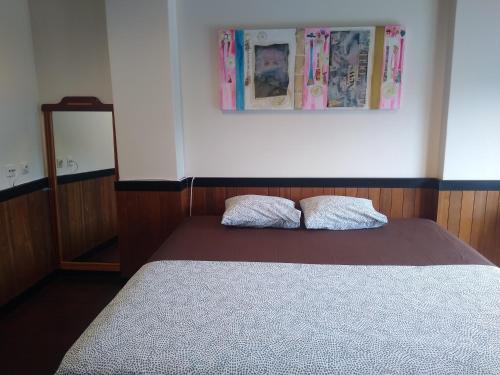 a bedroom with a bed with two pillows on it at Melaya Private Rooms in Faro