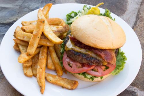 a white plate with a hamburger and french fries at Lodge at Whitefish Lake in Whitefish