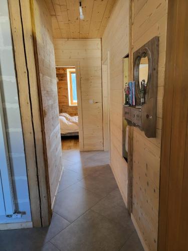 a hallway of a log cabin with a sink and a mirror at La Fessette in Chapelle-des-Bois