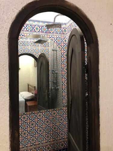 a mirror on the side of a wall with a room at Riad Razoli Sidi Fateh in Rabat