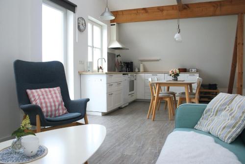 a living room with a table and chairs and a kitchen at Ferienwohnung Traumblick 