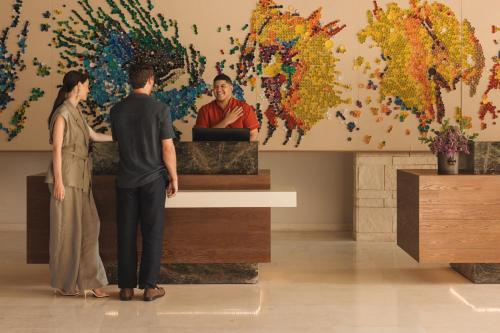 a man and a woman looking at a painting in a museum at Hyatt Zilara Cap Cana - Adults Only in Punta Cana