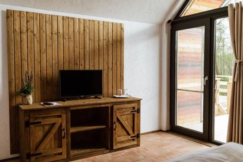 a living room with a television on a wooden desk at Pastravaria Zavoi in Valea Danului