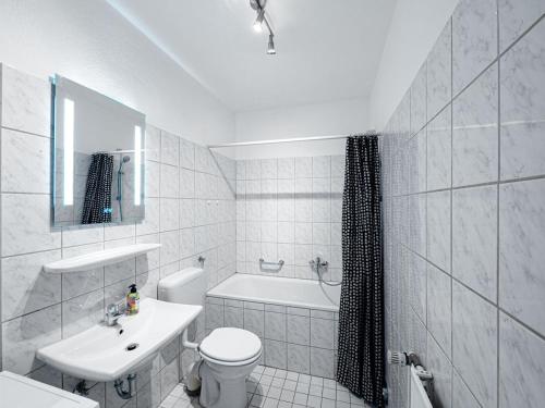 a white bathroom with a toilet and a sink at Workers Apartment with Balcony in Ratekau