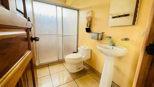 ein Badezimmer mit Toilette, Waschbecken und Dusche in der Unterkunft Cozy coworking Casa Alma near Lake Arenal, 2 bedroom 1 office, fiber optic, pet friendly in Nuevo Arenal