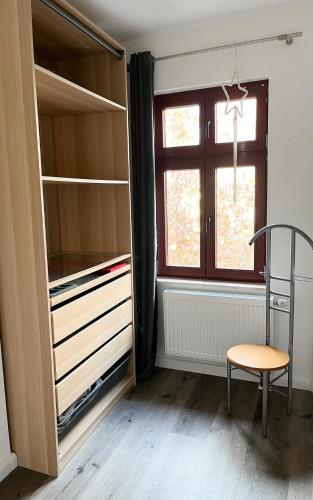 a room with a closet with a chair and a window at Ferienwohnung Kamrath Altstadt in Neuruppin