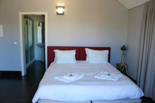 a bedroom with a white bed with towels on it at HI Serra da Estrela - Pousada de Juventude in Penhas da Saúde