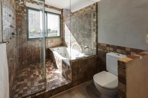 a bathroom with a tub and a toilet and a shower at Chalet Confort Gandia Playa in Gandía