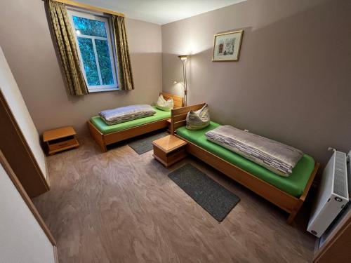 a small room with two beds and a television at Monteurunterkunft Zum Mohr in Birstein