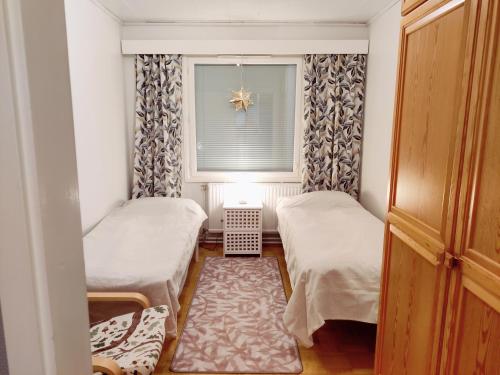 ein kleines Zimmer mit 2 Betten und einem Fenster in der Unterkunft Tilava asunto saunalla in Kuusamo