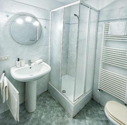 een witte badkamer met een douche en een wastafel bij La Dimora di Maggie in Florence