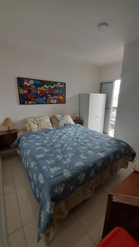 a bedroom with a bed with a blue comforter at Casa Nova Tatuapé in Sao Paulo