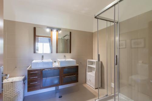 ヴィラモウラにあるCasa Claraのバスルーム(洗面台2台、ガラス張りのシャワー付)