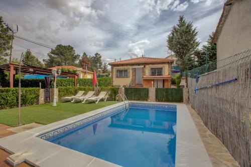 a swimming pool in a yard with a house at Casa rural Higueras in Santa María de la Alameda