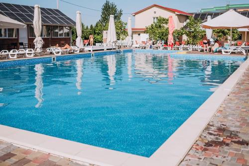 a swimming pool at a hotel with blue water at Райский Дворик in Pogreby