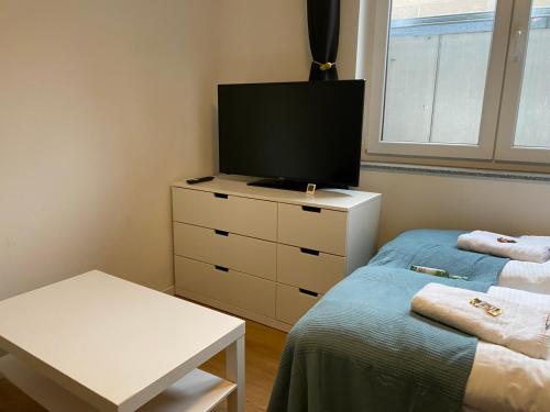 a bedroom with two beds and a tv on a dresser at LUX Apartments in Mörfelden-Walldorf