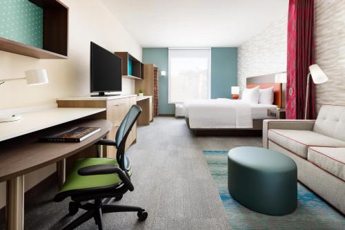 um quarto de hotel com uma secretária e uma cama em Home2 Suites By Hilton Lake Mary Orlando em Lake Mary