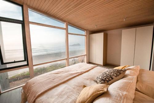 een slaapkamer met een groot bed en uitzicht op de oceaan bij NEK Matanzas in Matanzas