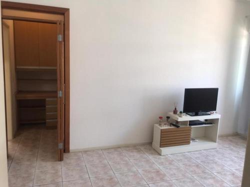 a room with a door open to a room with a television at Quarto e sala Boqueirão quadra da praia in Santos