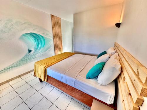 a bedroom with a bed with a painting on the wall at Hôtel Résidence Océane in Tartane