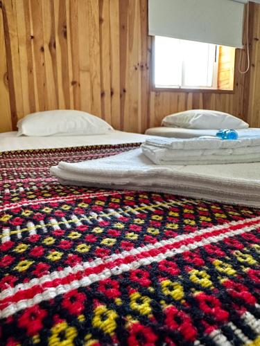 a bedroom with two beds and a crochet rug at HI Serra da Estrela - Pousada de Juventude in Penhas da Saúde