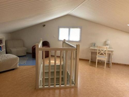 a attic room with a crib and a table at "LA VAGUE" Maison 6 personnes, terrasse, Port plaisance, garage vélos in Talmont