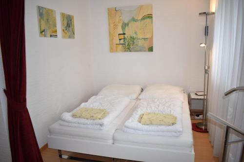 een witte bank in een kamer met twee kussens erop bij La Riva (159 Br) in Lenzerheide