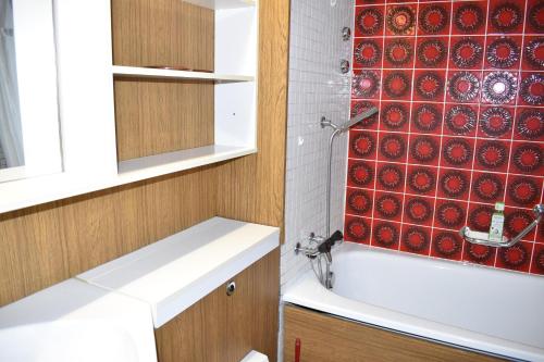 a bathroom with a shower and a red tile wall at La Riva (159 Br) in Lenzerheide