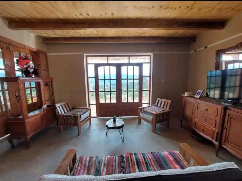 ein Wohnzimmer mit Sofa, Sesseln und Fernseher in der Unterkunft Hospedaje El Tayo - Casa de campo Cajamarca in Cajamarca
