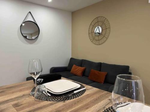 uma sala de estar com um sofá e uma mesa com copos de vinho em Appartement chaleureux en hyper centre de Gap em Gap