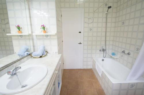 a white bathroom with a tub and a sink at Miramar K by Sonne Villas in Cala Galdana