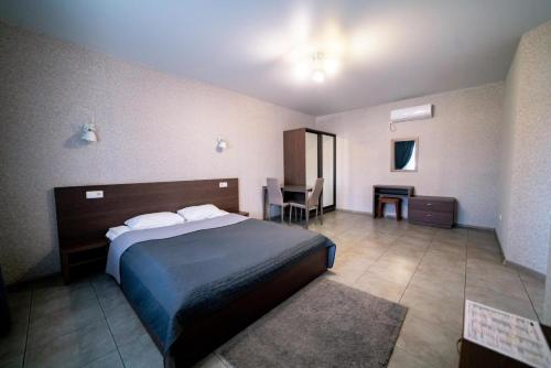 um quarto de hotel com uma cama e uma mesa em Райский Дворик em Pogreby