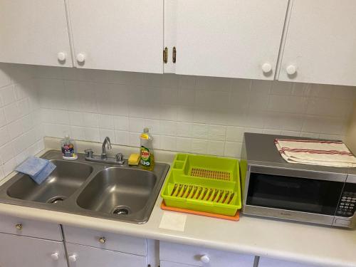 a kitchen counter with a sink and a microwave at Sunset condos getaway In Ocho Rios in Ocho Rios