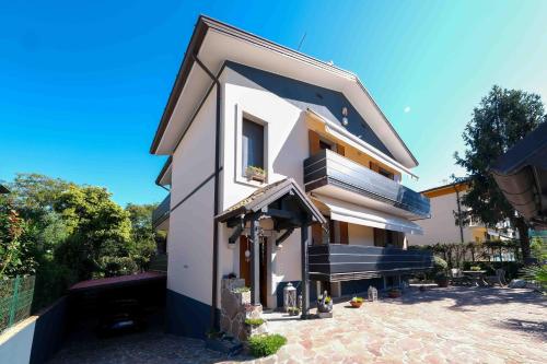 a white house with a balcony and a patio at Chiarelli House in Udine