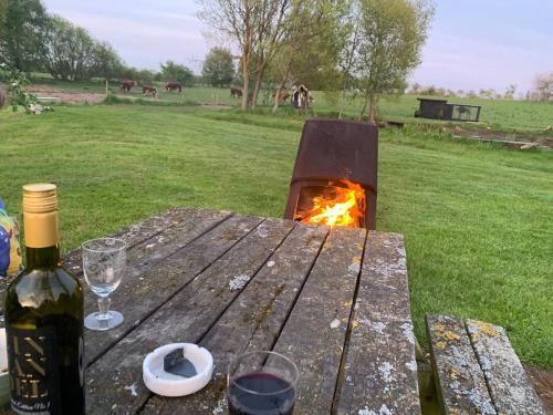 a bottle of wine and a glass on a wooden table at Kongsholmlund - Silent retreat in Vejby