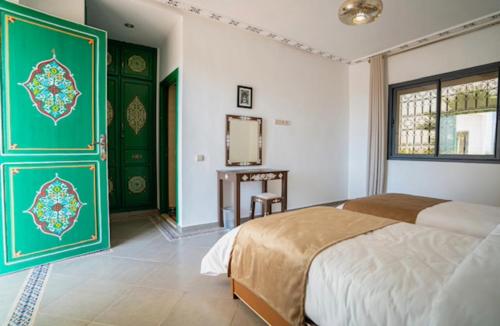 a bedroom with green and white walls and a bed at Villa Leila Farmhouse in Marrakech