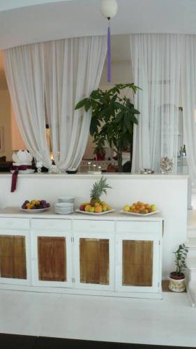 a white counter with plates of fruit on it at Il San Francesco Charming Hotel in Sabaudia