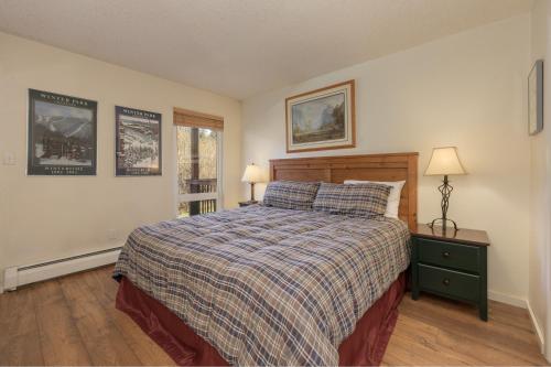a bedroom with a bed and two lamps and a window at Hi Country Haus Unit 1803 in Winter Park