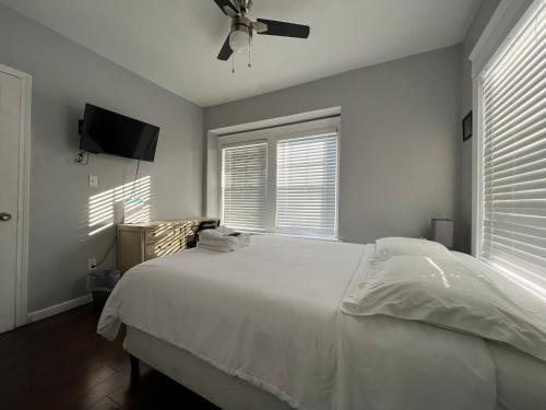 1 dormitorio con cama blanca y ventilador de techo en Stay with Jay Cleveland One en Cleveland