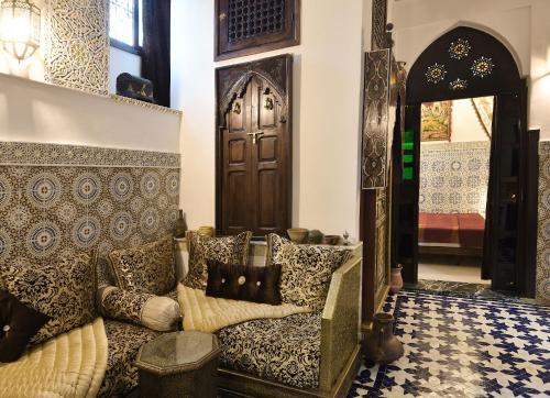 a living room with a couch in front of a door at Dar Aya Fes in Fès