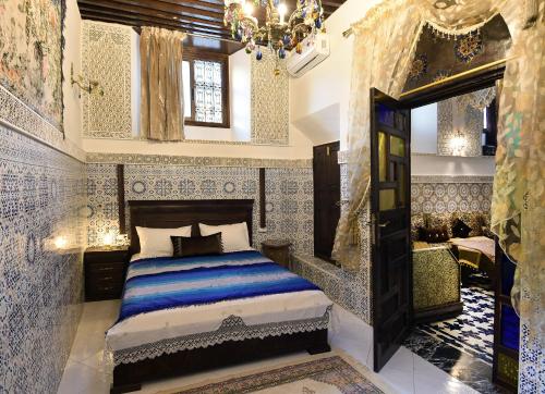 a bedroom with a bed and a chandelier at Dar Aya Fes in Fez