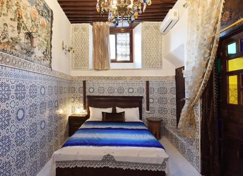 a bedroom with a bed with blue and white tiles at Dar Aya Fes in Fès