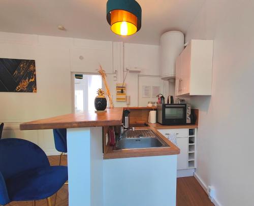 une cuisine avec un évier et un micro-ondes dans l'établissement Appart'HomeCity - Rouen Marne 1850, à Rouen