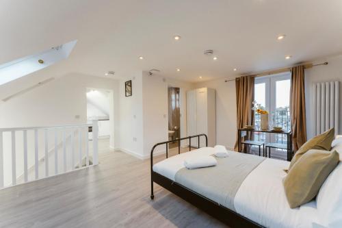 a bedroom with a large bed and a staircase at Perivale Studio Apartments in Perivale