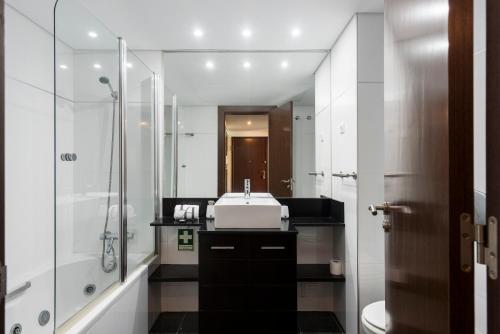 Apartamento Monte Laguna في فيلامورا: حمام أبيض مع حوض ودش