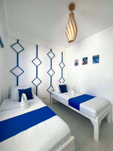 two beds in a room with blue and white at Issa's Haven Resort in Look